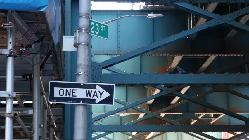 New York elevated subway, metropolitan bridge, metro track above street. Railway transport over road. Railroad line. One way roadsign. Construction scaffold. Long Island city, Queens, United States.