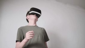 Teen boy standing in room, immersed in virtual reality headset game - Powered by Shutterstock - Get 15% off with code: PIKWIZARD15