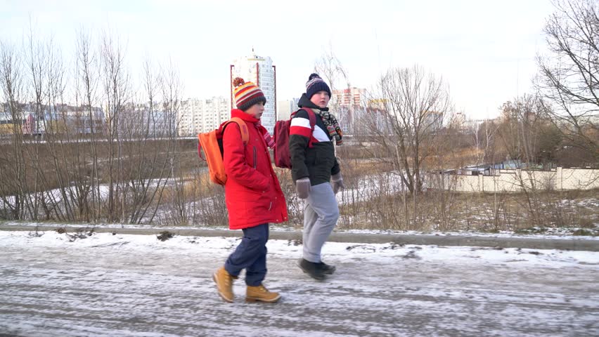 People walk in a snowy city.