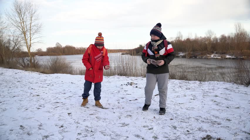 Strolling by a snowy riverbank.