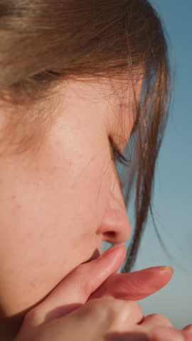 Close-up of a girl resting her head on her hands, her expression deeply sorrowful and contemplative. The image captures a moment of disconsolation, filled with melancholy and introspection