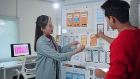 Professional ux designers collaborating on mobile app interface, analyzing sketches and discussing design improvements while strategizing user experience in modern startup office environment - Powered by Shutterstock - Get 15% off with code: PIKWIZARD15