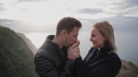 Romantic couple holding hands on cliff at sunset - Powered by Shutterstock - Get 15% off with code: PIKWIZARD15