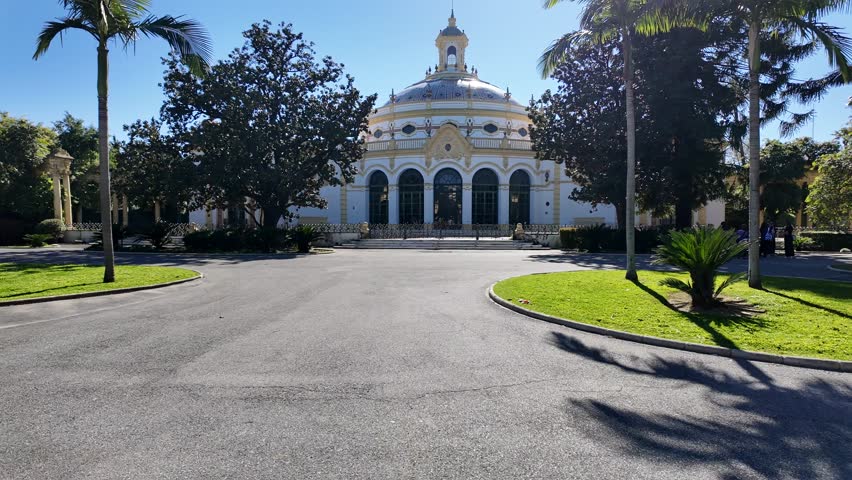 Lope de Vega Theatre And Exhibition Casino (Front Entrance Building Facade) On Avenida Maria Luisa, A Popular Tourist Area In Seville, Spain. Walking POV.