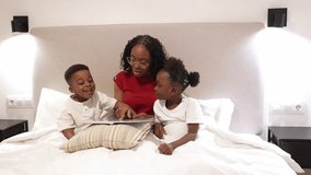 Loving mother reading bedtime story, nurturing children's literacy and imagination while sharing warm, intimate moment in cozy bedroom - Powered by Shutterstock - Get 15% off with code: PIKWIZARD15
