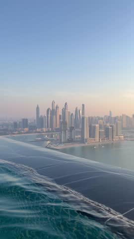 Aerial view of Dubai Palm Jumeirah island, United Arab Emirates. Tourists relaxing in AURA sky pool bar, the world
