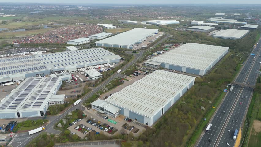 Drone footage of a large industrial park next to a busy motorway. Road, UK