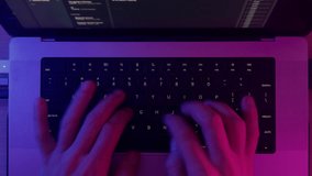 Video editing on laptop. Producer's hands press buttons on keyboard, uses touchpad. Creating video clip in movie software, interface. Neon light, pink and blue color. Color correction, film production - Powered by Shutterstock - Get 15% off with code: PIKWIZARD15