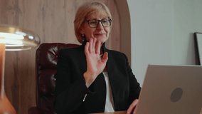 A 60-year-old woman initiates a remote class, greeting participants through video call. Her calm, supportive presence adds trust and relatability to the lifelong learning experience. 4k footage - Powered by Shutterstock - Get 15% off with code: PIKWIZARD15