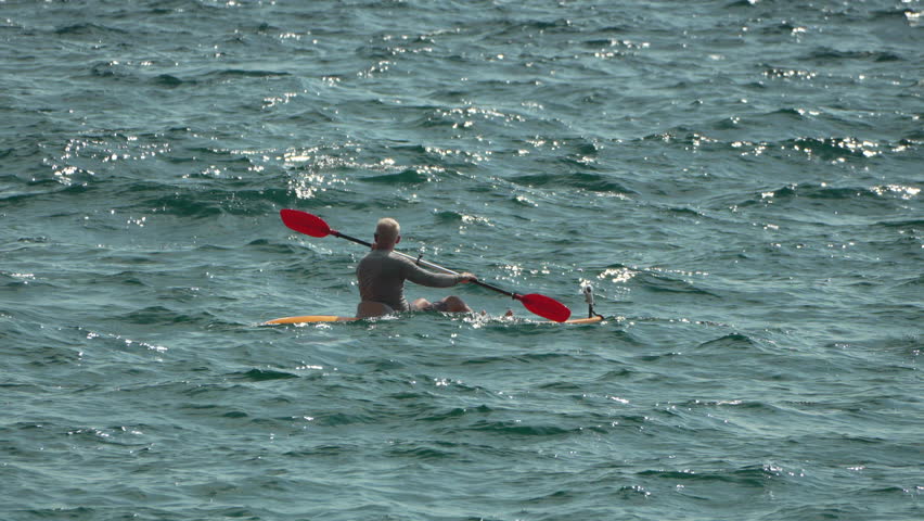 Kayaking Ocean Water Man Paddling through choppy water in a kayak on a cloudy day.