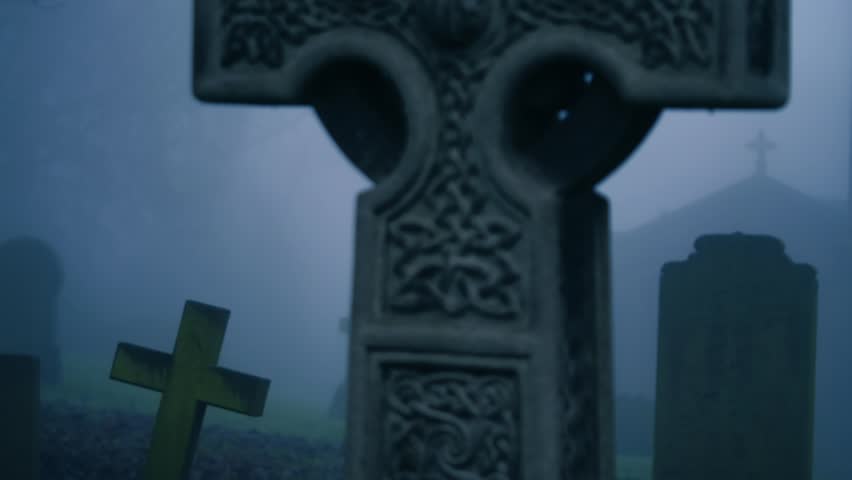 Eerie Graveyard in thick fog and mist medium zoom shot selective focus