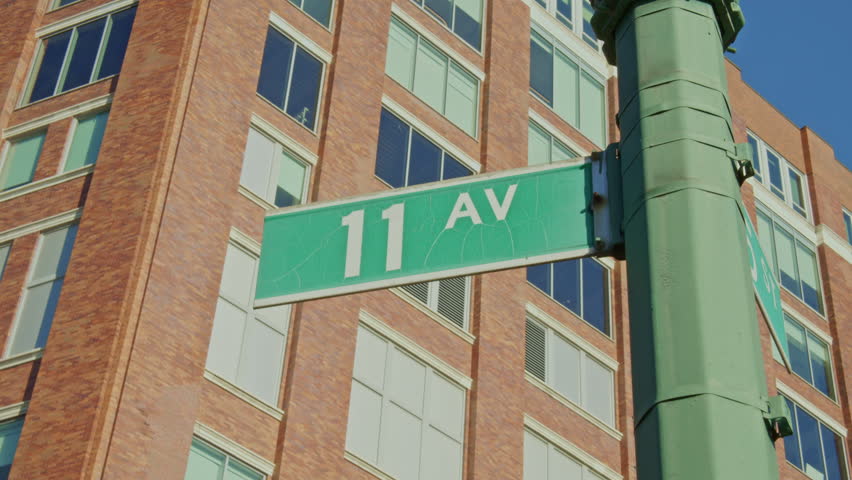 Street sign marking 11th Avenue standing amid Chelsea neighborhood, capturing Manhattan
