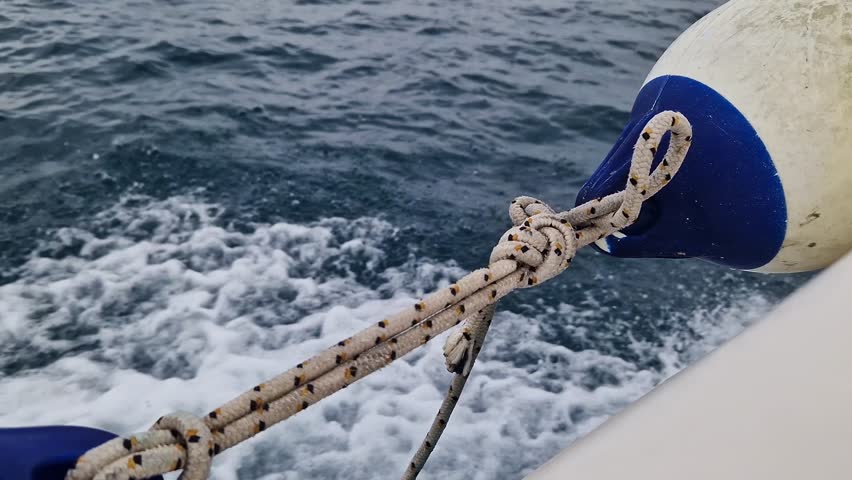 Boat bumper tied to the side of the boat. Marine fender or boat bumper close-up. Sea trip. Accessory. Fast boat ride on the sea, sea spray. Marine fenders. Plastic fender for a motorboat or sailboat