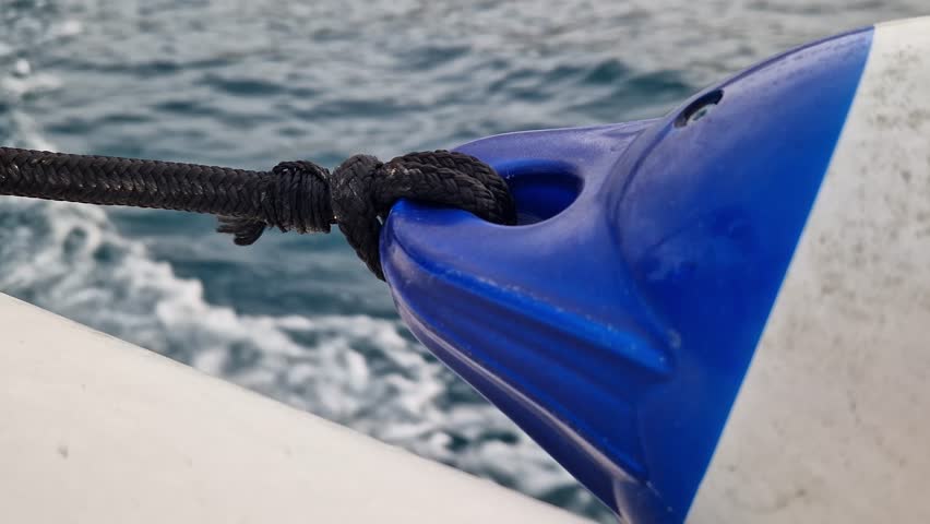 Boat bumper tied to the side of the boat. Marine fender or boat bumper close-up. Sea trip. Accessory. Fast boat ride on the sea, sea spray. Marine fenders. Plastic fender for a motorboat or sailboat