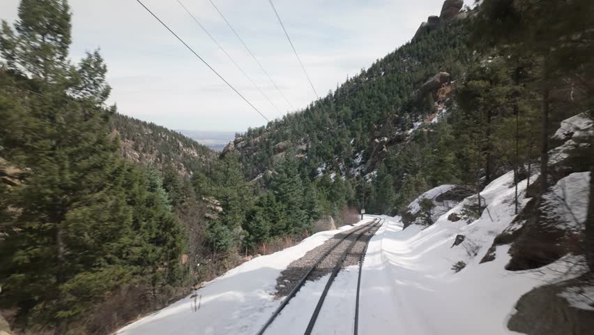 Manitou And Pikes Peak Cog Railway Through Snowy Mountain Pass In Colorado, USA. POV, pullback shot