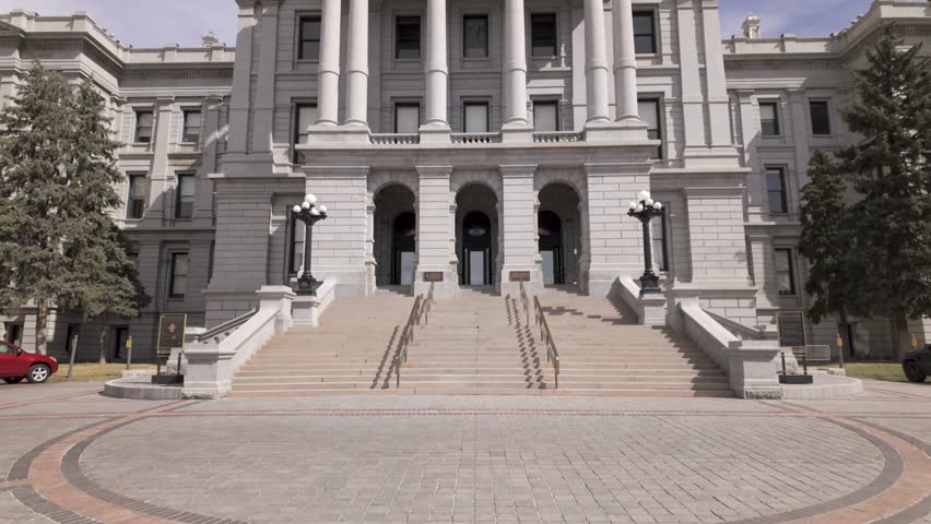 Colorado State Capitol Exterior Facade With Grand Columns And Flags Atop. low angle, tilt-up shot