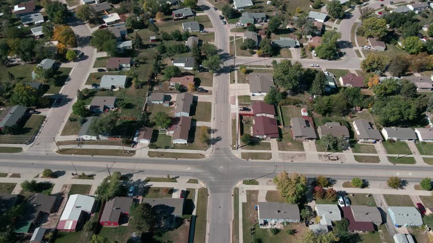 A drone flying backwards and panning the camera up revealing homes with hills in the background in Rapid City, South Dakota