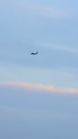 Minimal cinematic view of an airplane flying in a clear sky at sunset. Beautiful 4K shot with a vibrant gradient background. Perfect for ads, transitions, and title screens.