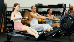 Young woman in sportswear training on rowing machine in gym - Powered by Shutterstock - Get 15% off with code: PIKWIZARD15