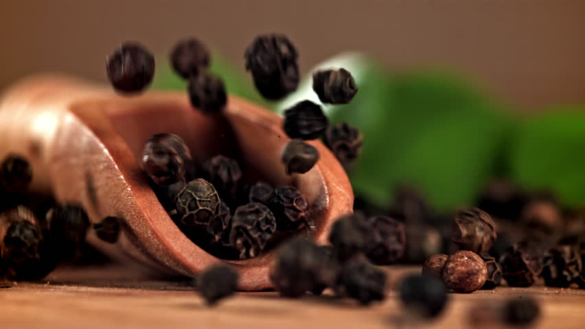 Black pepper falls on a wooden table. Filmed on a high-speed camera at 1000 fps. High quality FullHD footage