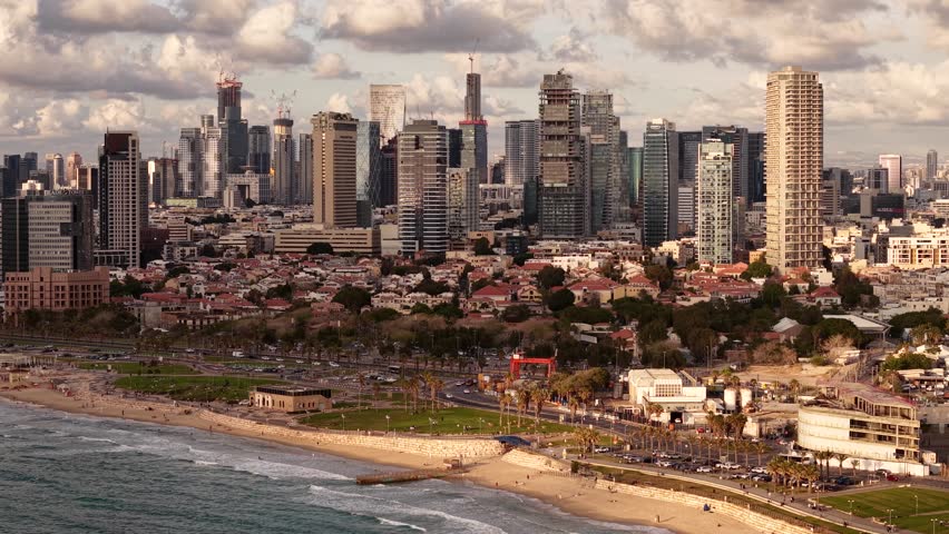 Aerial view of Tel Aviv’s bustling urban landscape, featuring modern skyscrapers alongside historic districts near the beach.