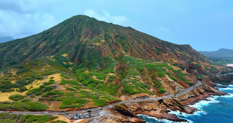 Striking view of the highway passing the foot of the rock. Diamond Head Crater from above the waterscape. Honolulu, Hawaii, USA.