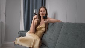 Professional sommelier in yellow dress analyzing wine characteristics using smartphone app while sitting on couch against blue curtain, showcasing modern wine expertise through mobile technology - Powered by Shutterstock - Get 15% off with code: PIKWIZARD15