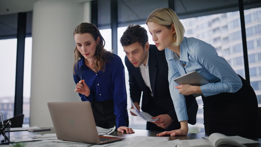 Business team failing deal looking laptop together with frustration. Three managers disappointed investment loss financial problem in office. Stressed partners reacting on company crisis emotionally.