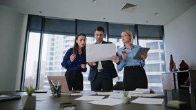 Group colleagues discussing project documentation in modern conference room. Three business managers collaborating on creative startup. Group office employees talking reviewing documents at workplace. - Powered by Shutterstock - Get 15% off with code: PIKWIZARD15