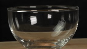 Roasted coffee beans falling into glass bowl on black background. Coffee beans slowly falling into glass jar on wooden rotating table on black background - Powered by Shutterstock - Get 15% off with code: PIKWIZARD15