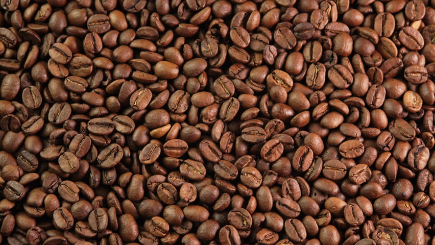 Roasted coffee beans rotating as background close-up wide angle. Concept for coffee shop with brown coffee beans rotating as background for advertising, promo, vending machine