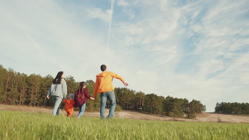 Happy family concept. outdoor activity on green grass. healthy lifestyle. family trip. vacation in nature. parents and children together on an active holiday. family vacation at sunset on green grass