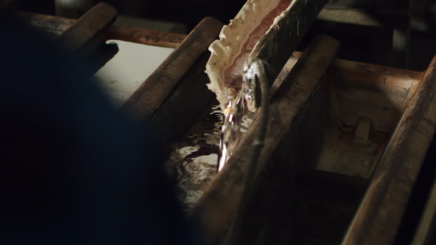 4K Stream of molten aluminum pouring from furnace, industrial metal casting process, heavy manufacturing, material refinement, recycling in the aluminum industry