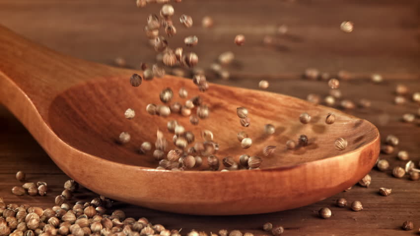Coriander grains fall on a wooden spoon. Filmed on a high-speed camera at 1000 fps. High quality FullHD footage