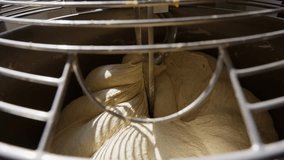 Dough is kneaded in a dough mixer in the kitchen of a bakery. A professional baker kneads bread and pastries. High quality 4k footage - Powered by Shutterstock - Get 15% off with code: PIKWIZARD15