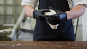 Baking process in a bakery close-up of a baker mixing, kneading, and forming bread dough, professional craftsmanship in traditional artisan baking. High quality 4k footage - Powered by Shutterstock - Get 15% off with code: PIKWIZARD15