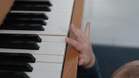 Hands of child musician learning to play piano, musical instrument, close-up. Baby trying to play the piano, learning music. Little kid fingers press the piano keys - Powered by Shutterstock - Get 15% off with code: PIKWIZARD15