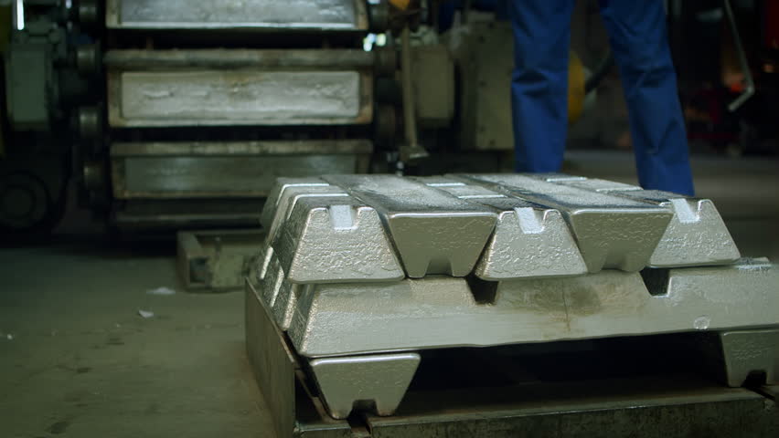 4K Industrial aluminum casting process, stacked aluminum ingots in production plant, heavy machinery, recycling, raw material preparation, and metal manufacturing operations