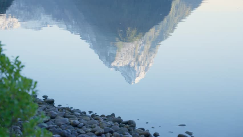 Mitre Peak in Milford Sound in New Zealand reflecting on water during winter. Snow capped famous mountain range in beautiful Fiordland National Park. Mirror like reflection in puddle outdoors