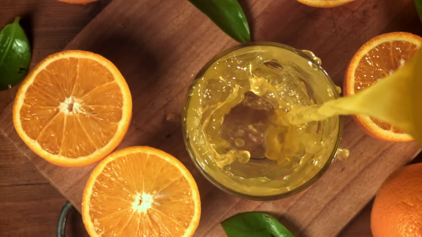 Orange juice is poured into a glass. Filmed on a high-speed camera at 1000 fps. High quality FullHD footage