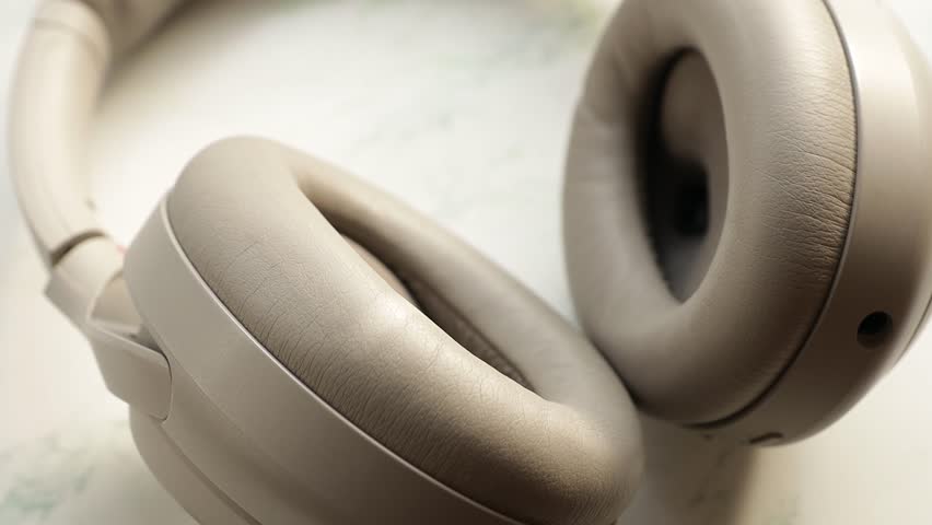 A pair of headphones sits on a table, ready for use.