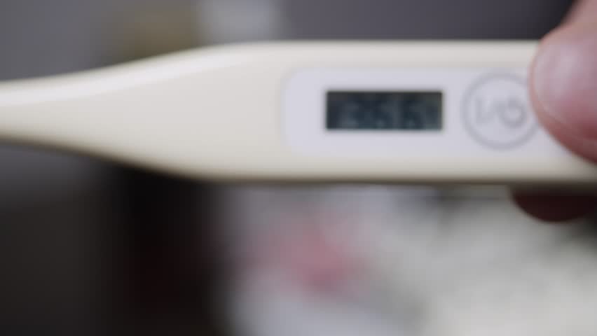 Close-up of an electronic thermometer display, showing normal values for healthy human body temperature, in numerical form.