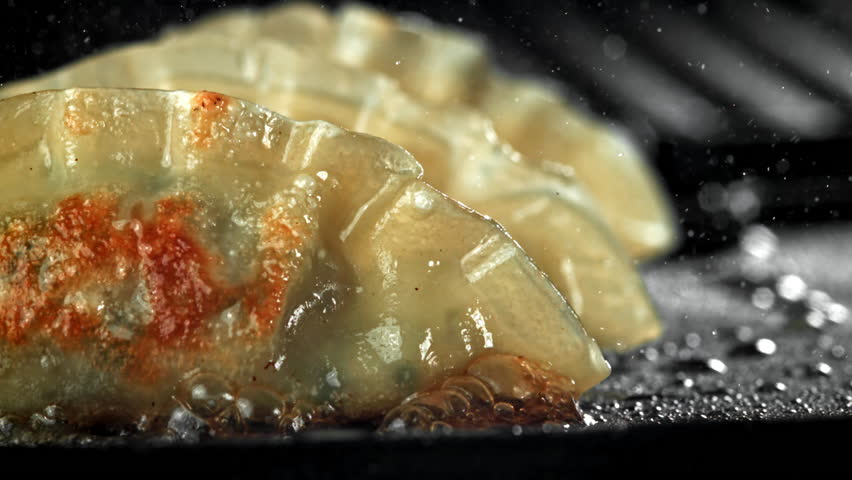 Traditional gyoze dumplings are fried in a pan. Filmed on a high-speed camera at 1000 fps. High quality FullHD footage