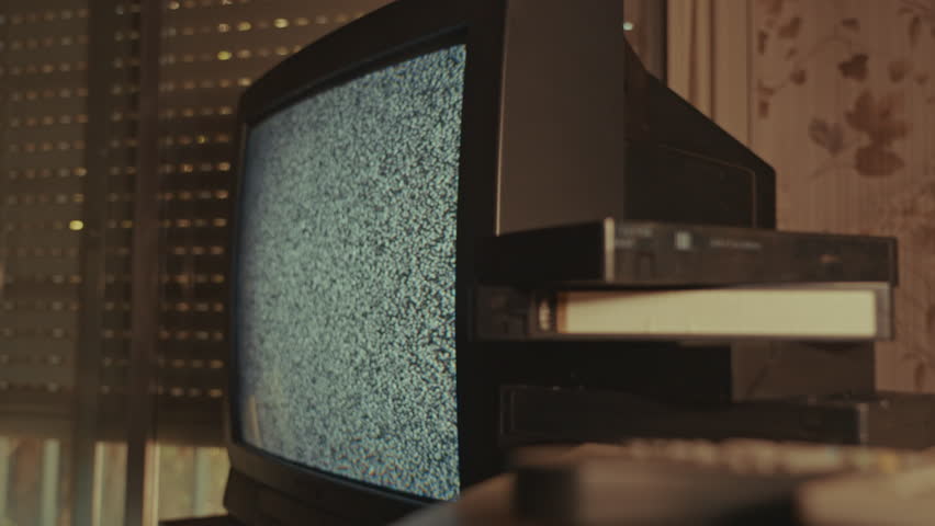 Vintage CRT TV with Static and VHS Tapes in Retro Room
