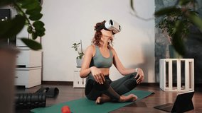 Young woman sitting in lotus position on yoga mat at home, wearing virtual reality headset for immersive workout meditation experience. Modern technology meets healthy lifestyle in cozy home interior. - Powered by Shutterstock - Get 15% off with code: PIKWIZARD15