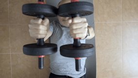A determined senior man lifting dumbbells in a home environment, demonstrating strength and physical fitness. The image reflects dedication to personal health and resistance training  - Powered by Shutterstock - Get 15% off with code: PIKWIZARD15