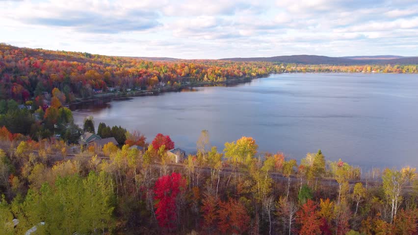 Colorful autumn landscape in Estrie, Québec with vibrant trees by a calm lake