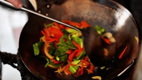 Video footage of a chef stir-frying vegetables and eggs for a vegetarian fried rice dish in a Stir-fry pan , Home kitchen. - Powered by Shutterstock - Get 15% off with code: PIKWIZARD15