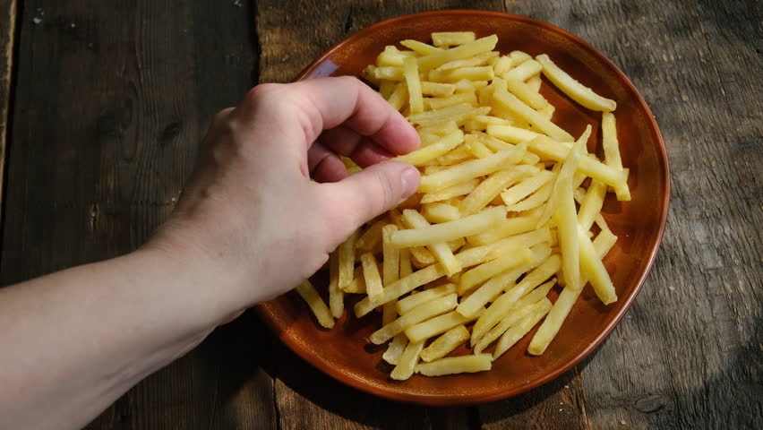 Woman is enjoying french fries. Fast food, greasy snack.