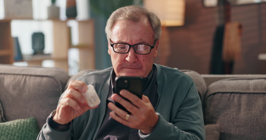 Senior man, phone and pills on sofa with search, online shopping or check label for product ingredients. Elderly person, smartphone and medicine with mobile app for order, info or benefits in home